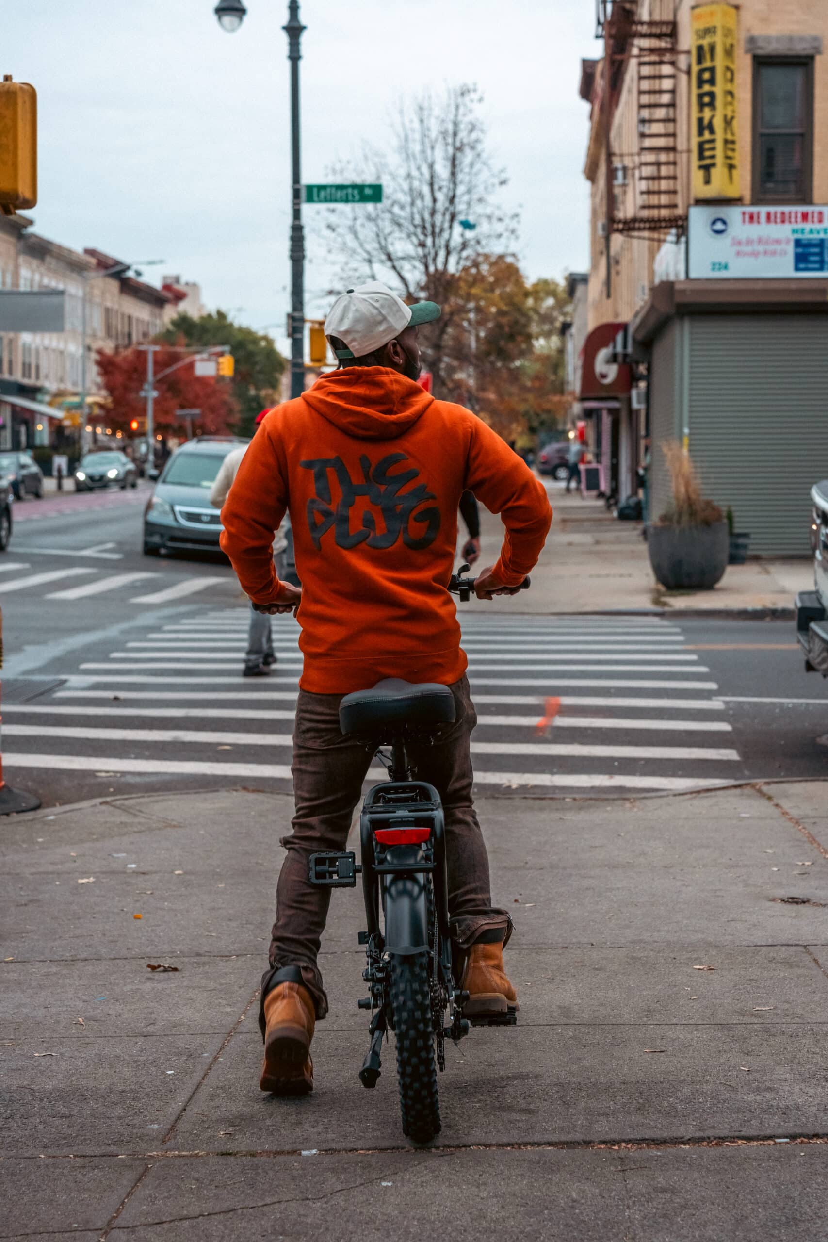 Man riding bike wearing The Plug merch